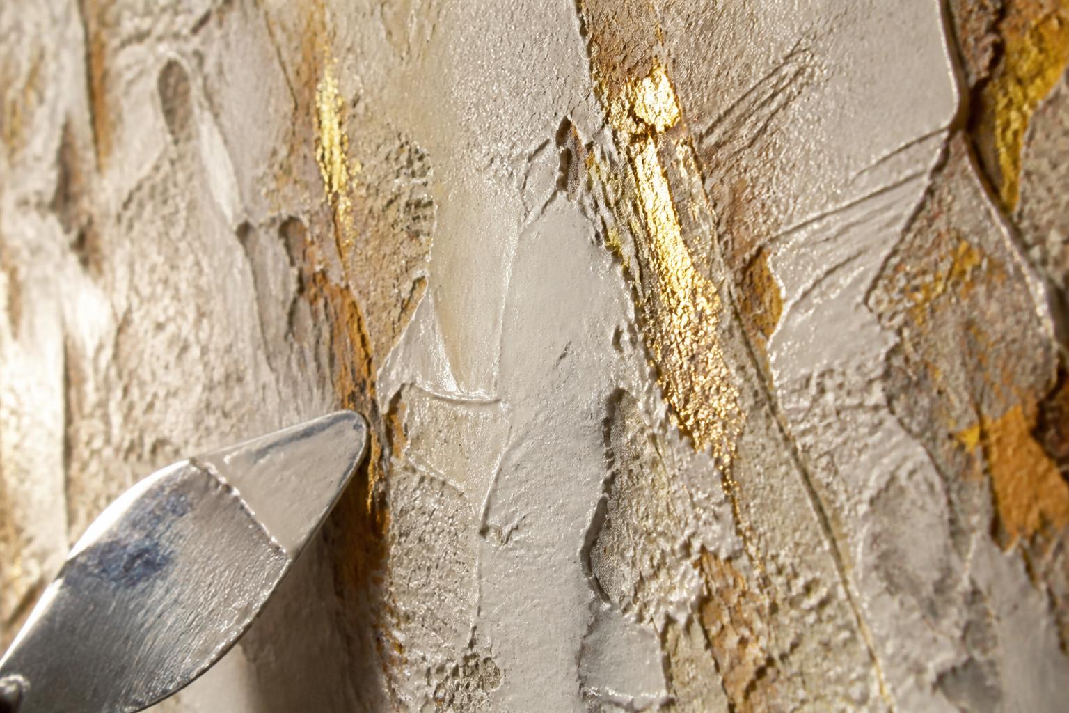 Détail de matière — plâtre texturé, feuille d'or et couteau de peintre.